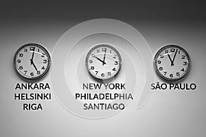 Many wall clocks on the white wall of business office showing time of different cities of the world
