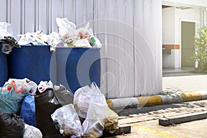 Many waste pile at plastic bin blue color for recycle garbage waste outdoors front zinc wall, plastic bin of garbage, bin trash