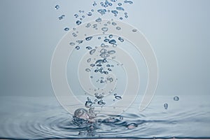 Many water droplets are both sharp and blurry. Falling on the water surface light blue