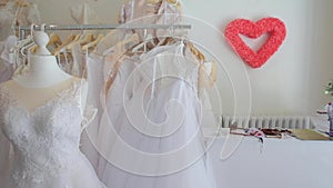 Many wedding dresses hanging on hangers