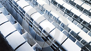 Many white aluminum or bimetal heating radiators stand next to each other on a stand in a store