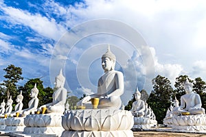 Many white buddha statues sitting in row on thai temple