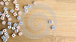 Many white dice with red and blue dots on wooden table. Casino gambling concept. Close-up