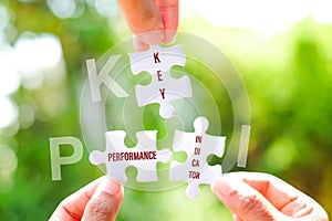 Many white jigsaw puzzle and KPI key performance indicator word on blue background - idea solution concept