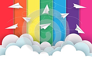 Many white paper planes fly on the background rainbow colorful while flying above a cloud