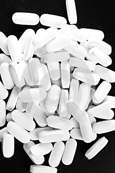 Many white pills isolated on black