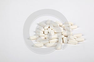 Many White pills scattered on a white background