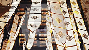 Many white ribbons with gold ornaments flutter in the wind in a Buddhist temple in Southeast Asia. Buddhist symbols Tung