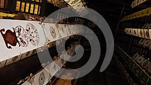 Many white ribbons with gold ornaments flutter in the wind in a Buddhist temple in Southeast Asia. Buddhist symbols Tung