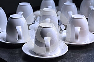 Many white tea and coffee cups on black background