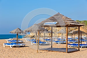 Many wicker parasols and beach beds