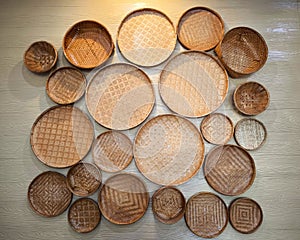 Many wicker tray wall hanging decoration on the concrete wall. The home interior decor