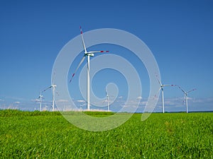 Many wind turbines standing on German field with lush green grass in spring, Nordfriesland, Germany, Europe