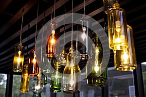 Many wine bottles hanging from the ceiling of a bar as chandeliers.