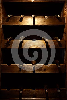 Many wine bottles on a wooden shelf