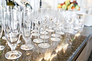 Many wineglasses. Breakfast in restaurant of hotel. Plate with fruits and berries on a smorgasbord in the background. Bar