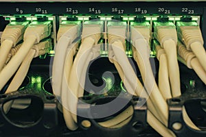 Many wires connect to the ports of a powerful router. Internet switch with gigabit links is a close-up. The cables patch panel