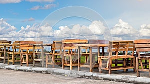 Many wood benches with sky clouds.