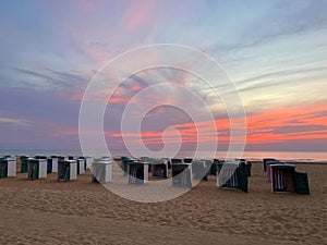 Many wooden beach huts on seacoast at sunset