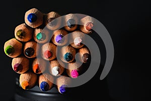 Many wooden crayons that have been used in the dark background are macro images