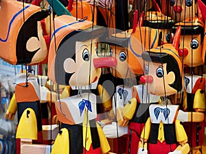 Many wooden Pinocchio puppets at a market