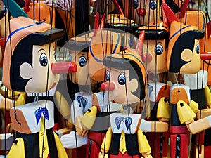 Many wooden Pinocchio puppets at a market