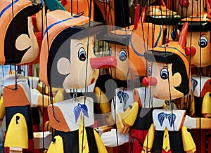 Many wooden Pinocchio puppets at a market