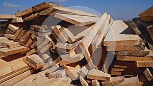 Many wooden planks lie on the ground in the open air. Building materials.