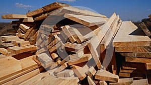 Many wooden planks lie on the ground in the open air. Building materials.