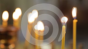 Many yellow candles burning in church? Close up.