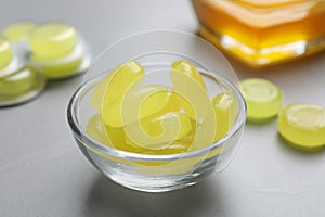 Many yellow cough drops on light grey table