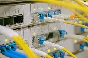 Many yellow internet cables. Front panel of the central router with a set of optical links is in the server room of the data