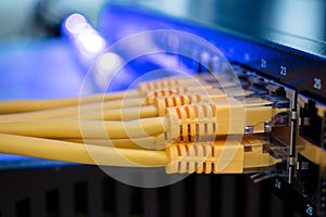 Many yellow internet wires connect to the network switch in the server room. Utp cable connects to the interfaces of the main