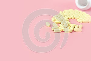 Many yellow tablets pills medicine medical on pink background