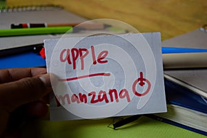 Manzana write on a sticky note isolated on Office Desk. Learning Spanish Language concept