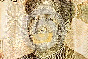 Mao portrait, leader of China with closed mouth on a banknote of Chinese Yuan, as a symbol of the instability of economy