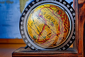 Map of Africa on an ancient globe with world map in the background