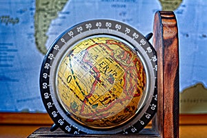 Map of Africa on an ancient globe with world map in the background