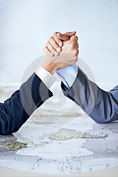 Map, arm wrestle and power struggle with business people in studio for battle, competition or war. Hands, strategy or