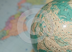 Map of Asia on the globe with a map of the earth in the background