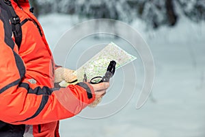 Map and compass in the hands of a lost tourist