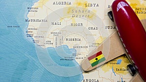 A map of Ghana and a red plane with a flag of Ghana attached to its wings.