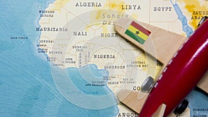 A map of Ghana and a red plane with a flag of Ghana attached to its wings.