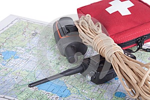 Map, gps navigator, portable radio, rope and first aid kit on a