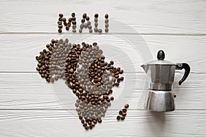 Map of the Mali made of roasted coffee beans laying on white wooden textured background with coffee maker