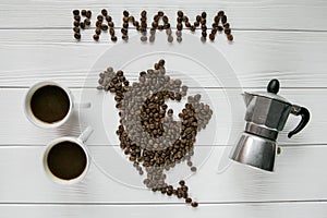 Map of the Panama made of roasted coffee beans laying on white wooden textured background with cups of coffee and coffee maker