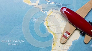 A map of Peru and a red plane with a flag of Peru attached to its wings.