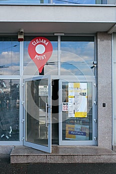 Map pointer affixed to the front entrance of a modern business building in Cluj Napoca,  Romania