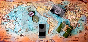 World map with phone, photo camera, compass and binocular