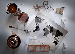 Map of the world, lined with tea leaves. Eurasia, America, Australia, Africa. vintage. sugar, note, cracker, spoon. top